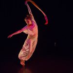 dancer leaning sideways with ribbon in her hand